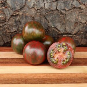 Frutos redondos color púrpura con rayas verdes del Tomate Violet Jasper cultivados de semillas orgánicas en Chile